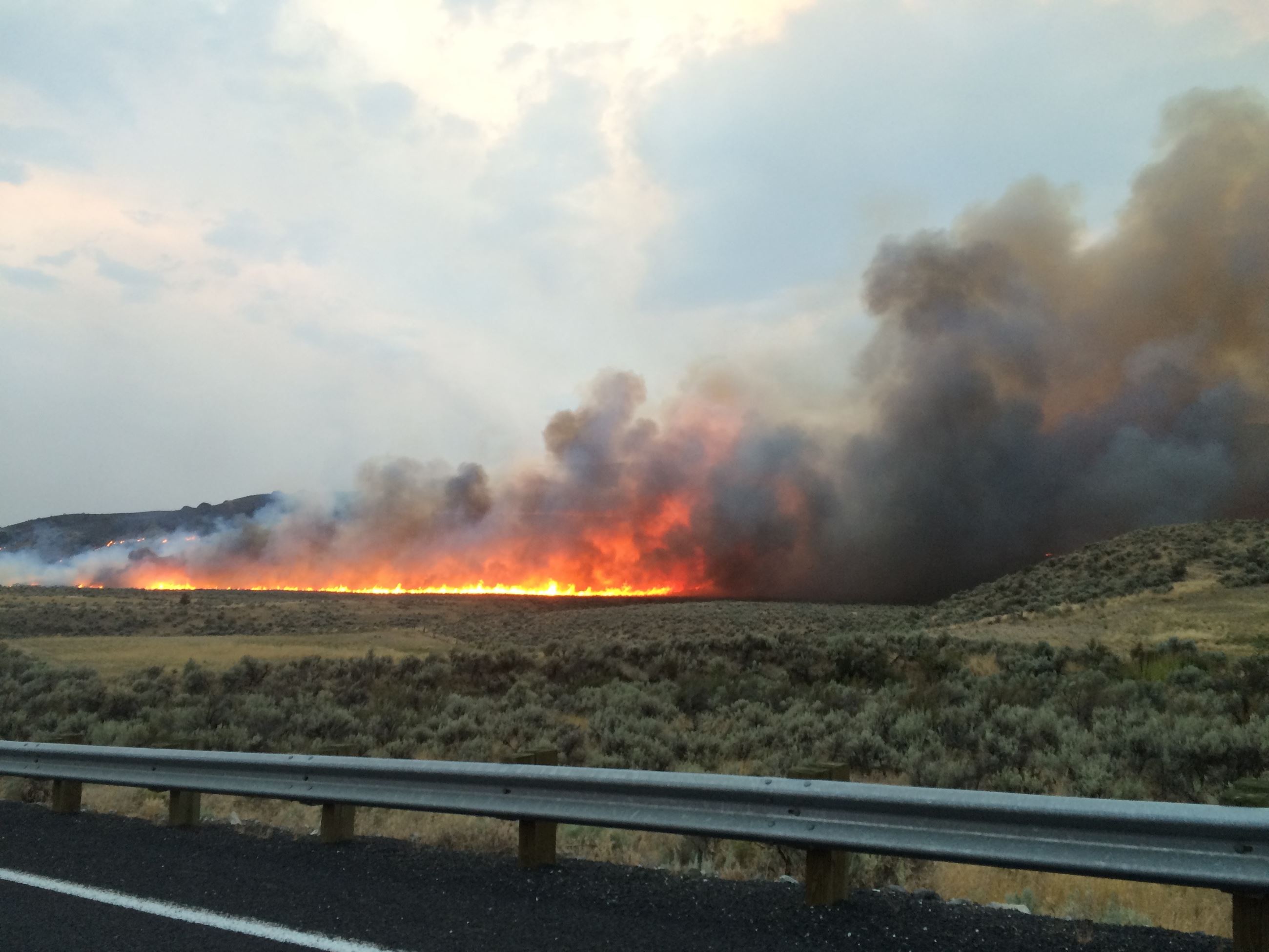 roadside guardrail and grass on fire