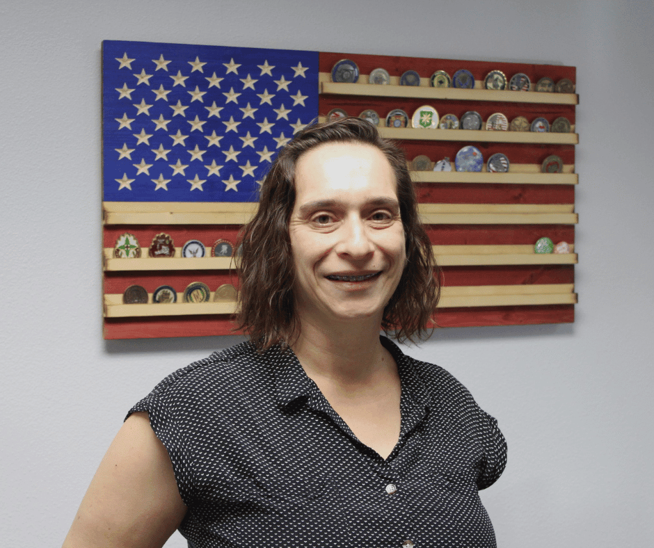 Sarah stands in the Veterans Service Office in front of American flag wall art