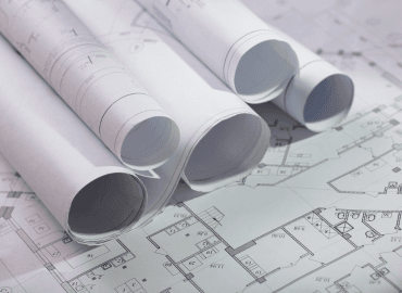 numerous architectural drawings rolled up on a table