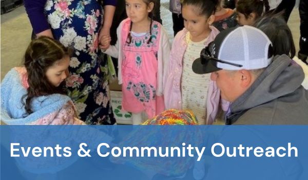 Photo of a group of children looking at recycled materials with words "events & community outreac